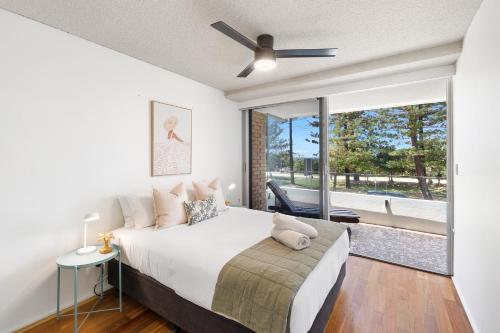 a bedroom with a bed and a ceiling fan at Beachfront Retreat at Burleigh, Breezy and Cosy in Gold Coast