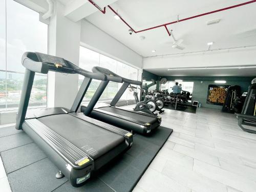 a gym with two treadmills and a treadmill at Queensland Suites at Aru Suites, Kota Kinabalu 2 Bedroom Family Suite in Kota Kinabalu