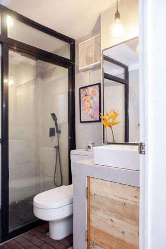 a bathroom with a toilet and a sink and a shower at E-Place Resort in Magallanes