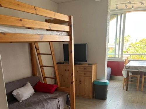 - une chambre avec des lits superposés, un canapé et une télévision dans l'établissement Studio avec parking privé à 500m de la plage - FR-1-338-603, à Sète