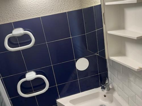 La salle de bains est pourvue de carrelage bleu, d'une douche et d'un lavabo. dans l'établissement Studio avec parking privé à 500m de la plage - FR-1-338-603, à Sète