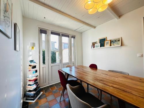 une salle à manger avec une table et des chaises en bois dans l'établissement Charmante maisonnette à Fouras, 200m de la plage, idéale pour 4 personnes - FR-1-709-86, à Fouras