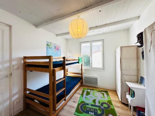 une chambre avec lits superposés dans un dortoir dans l'établissement Charmante maisonnette à Fouras, 200m de la plage, idéale pour 4 personnes - FR-1-709-86, à Fouras