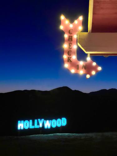 a group of lights hanging from a sign with a hollywood sign at Beyond: Historic Rock & Roll Studio in Sunfair Heights