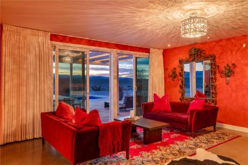 a living room with red furniture and a large window at Beyond: Historic Rock & Roll Studio in Sunfair Heights