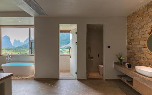 een badkamer met een bad, een wastafel en een bad bij Yangshuo One Thousand and One Courtyard Views B&B in Yangshuo
