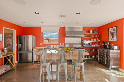a kitchen with orange walls and a table and chairs at Beyond: Historic Rock & Roll Studio in Sunfair Heights