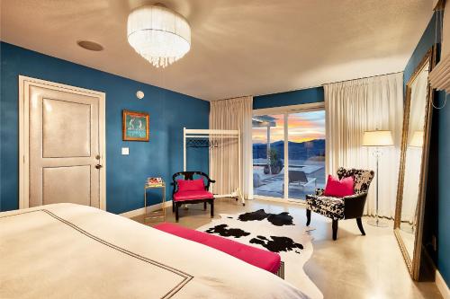 a bedroom with blue walls and a bed and a couch at Beyond: Historic Rock & Roll Studio in Sunfair Heights