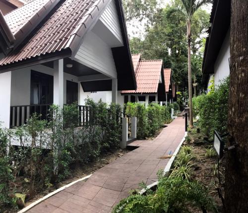 a walkway in front of a house with trees at Tok Little Hut in Rayong