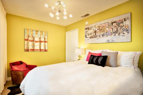 a bedroom with a large white bed and yellow walls at Beyond: Historic Rock & Roll Studio in Sunfair Heights