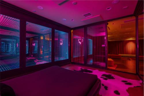 a bedroom with purple lights and a bed in a room at Beyond: Historic Rock & Roll Studio in Sunfair Heights