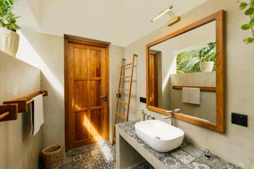 a bathroom with a sink and a mirror at Kandakuliya Sunrise Beach Villas in Kalladi