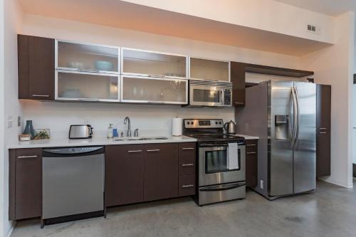 a kitchen with brown cabinets and stainless steel appliances at 5M412- Sophisticated 1BR Condo in Nashville