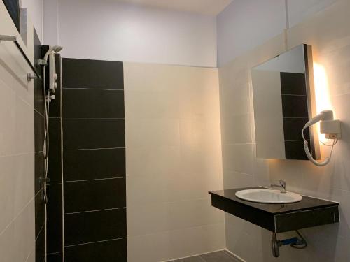 a bathroom with a sink and a mirror at Tok Little Hut in Rayong