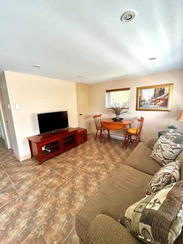 a living room with a couch and a television at Water front Golden Lake cottage - Calm and peaceful in Val-David