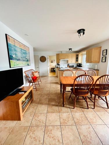 a living room with a table and chairs and a kitchen at Water front Golden Lake cottage - Calm and peaceful in Val-David