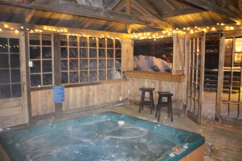 a jacuzzi tub in a room with a bar at Chalets et Studios Le Vent Du Nord in Lac-Superieur