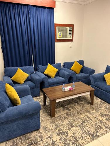 a living room with blue couches and a coffee table at أجنحة المدينة للشقق المفروشة in Al Madinah
