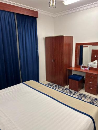 a bedroom with a bed and a desk and a mirror at أجنحة المدينة للشقق المفروشة in Al Madinah