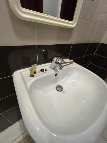 a white sink in a bathroom with a mirror at أجنحة المدينة للشقق المفروشة in Al Madinah