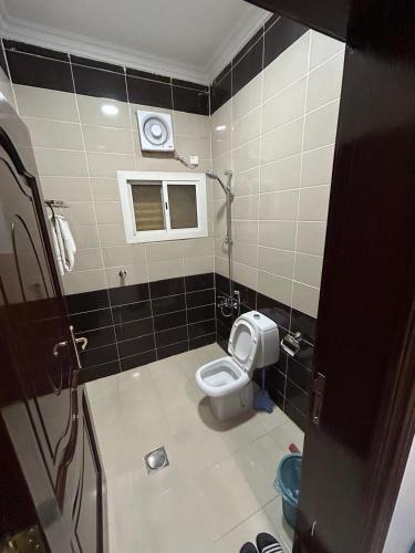 a small bathroom with a toilet and a window at أجنحة المدينة للشقق المفروشة in Al Madinah