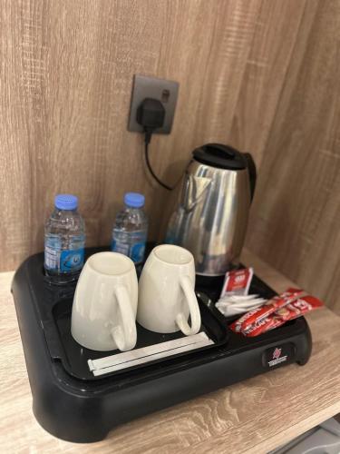 a tray with two coffee cups and water bottles at أجنحة المدينة للشقق المفروشة in Al Madinah