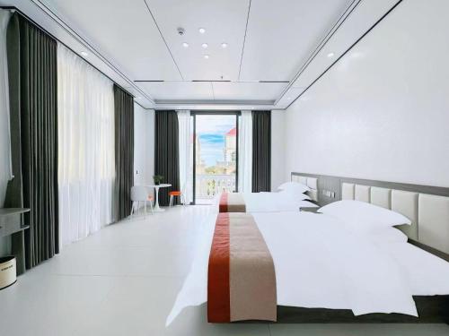 a bedroom with two beds and a large window at Meizhou Island Zhengxinju Homestay in Xiashan