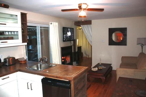 a kitchen with a sink and a living room at Chalets et Studios Le Vent Du Nord in Lac-Superieur