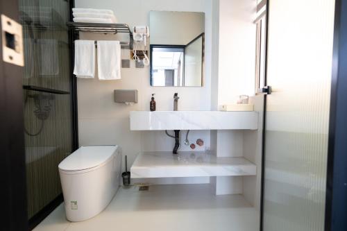 a bathroom with a white sink and a toilet at Meizhou Island Zhengxinju Homestay in Xiashan