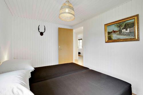a bedroom with a bed and a picture on the wall at Lovely Cottage For Family And Friends in Kirke-Hyllinge