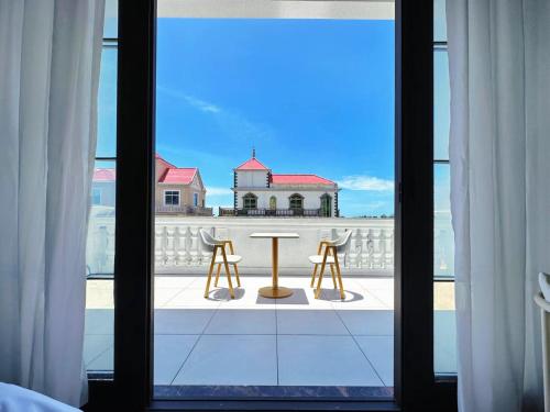 a view of a table and chairs from a window at Meizhou Island Zhengxinju Homestay in Xiashan