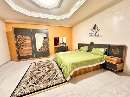 a bedroom with a green bed and a mirror at Grand Plaza in Nouakchott