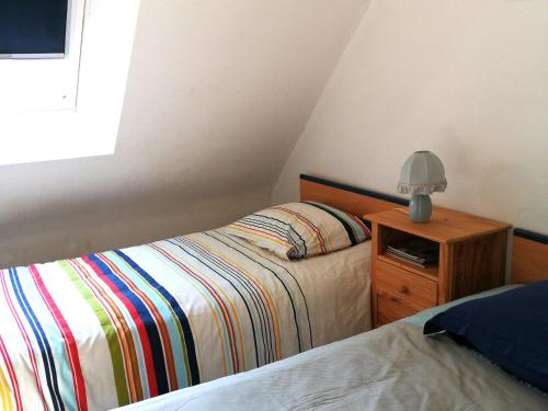 a bedroom with two beds and a lamp on a night stand at Spacieuse maison familiale à Groix avec jardin - FR-1-813-21 in Groix