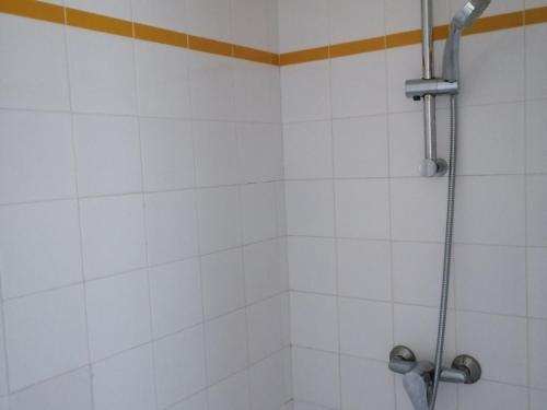 a bathroom with a shower with white tiles at Spacieuse maison familiale à Groix avec jardin - FR-1-813-21 in Groix