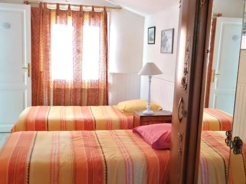 a bedroom with two beds and a window at Spacieuse maison familiale à Groix avec jardin - FR-1-813-21 in Groix