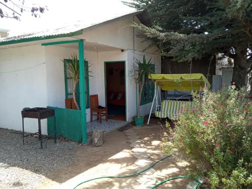 mały biały dom z gankiem i huśtawką w obiekcie Casa de Veraneo en La Herradura w mieście Coquimbo
