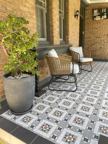 a patio with two chairs and a potted plant at Stay on March in Orange