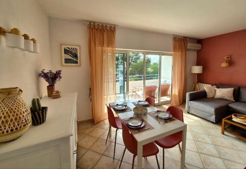 un salon avec une table, des chaises et un canapé dans l'établissement Appart Hôtel French Riviera, à Saint-Raphaël