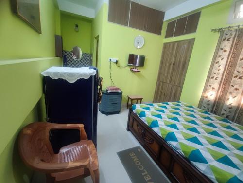 a bedroom with a bed and a chair in it at Prashaanti in Guwahati