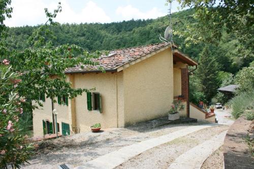 a small house with green shutters on a mountain at La Rogaia in Viciomaggio