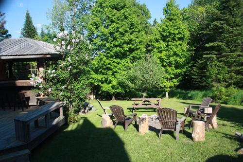 a group of chairs and a table in a yard at Chalets et Studios Le Vent Du Nord in Lac-Superieur