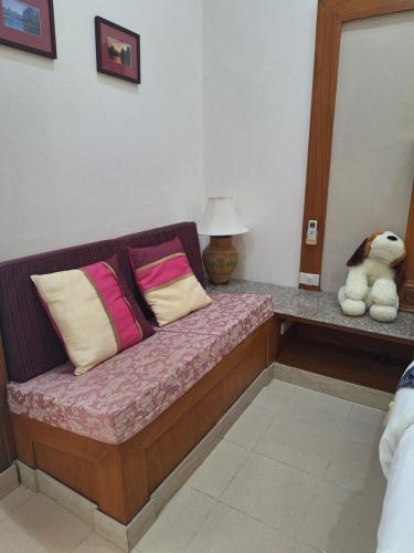 a couch with pillows and a teddy bear in a room at Rosie Garden & Home in Na Jomtien