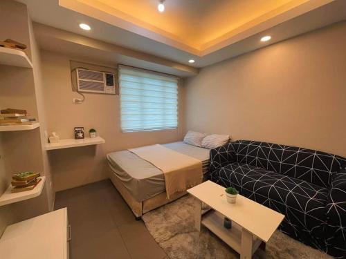 a living room with a bed and a couch at Mplace TOWER A Studio in Manila
