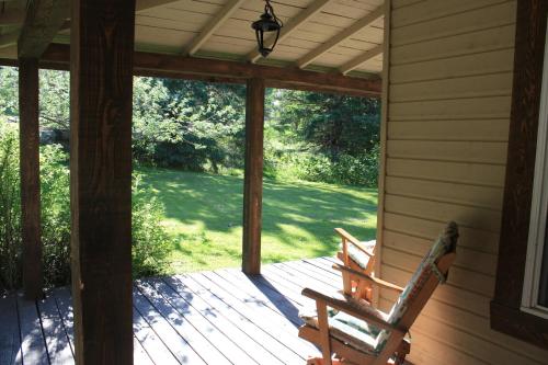 a porch with two wooden benches on a house at Chalets et Studios Le Vent Du Nord in Lac-Superieur