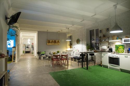 a kitchen and dining room with a green rug at Bla Bla Hostel in Krasnodar