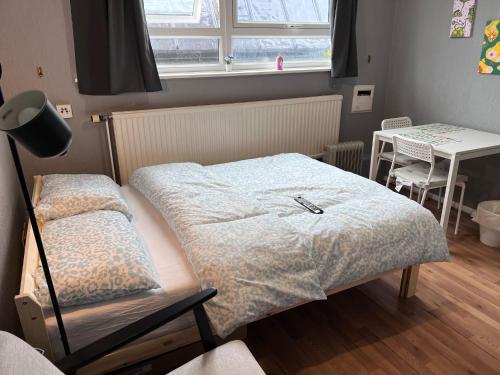 a bedroom with a bed and a table and a window at The Friary House - Central Guildford Personal 1 Bedroom Budget Apartment in Guildford
