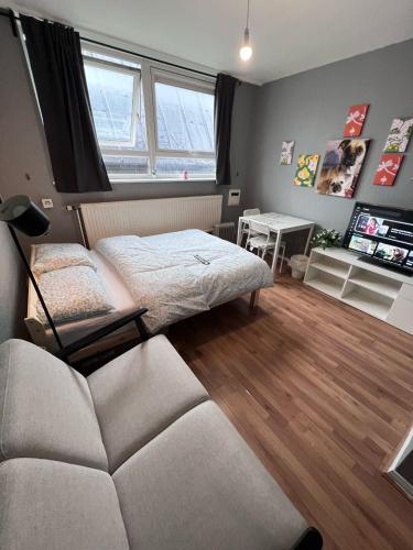 a bedroom with a bed and a couch and a table at The Friary House - Central Guildford Personal 1 Bedroom Budget Apartment in Guildford