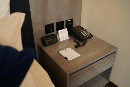 a desk with a phone on top of a bed at Best Western Hotel Rawalpindi Central in Rawalpindi