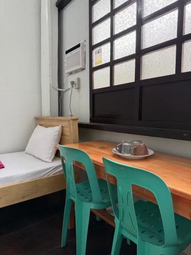 a room with a table and two chairs and a bed at Agoo Tourist Cabin in Agoo