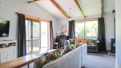 a living room with a couch and a tv at Large, Comfy, Stylish Apartment in Havelock North
